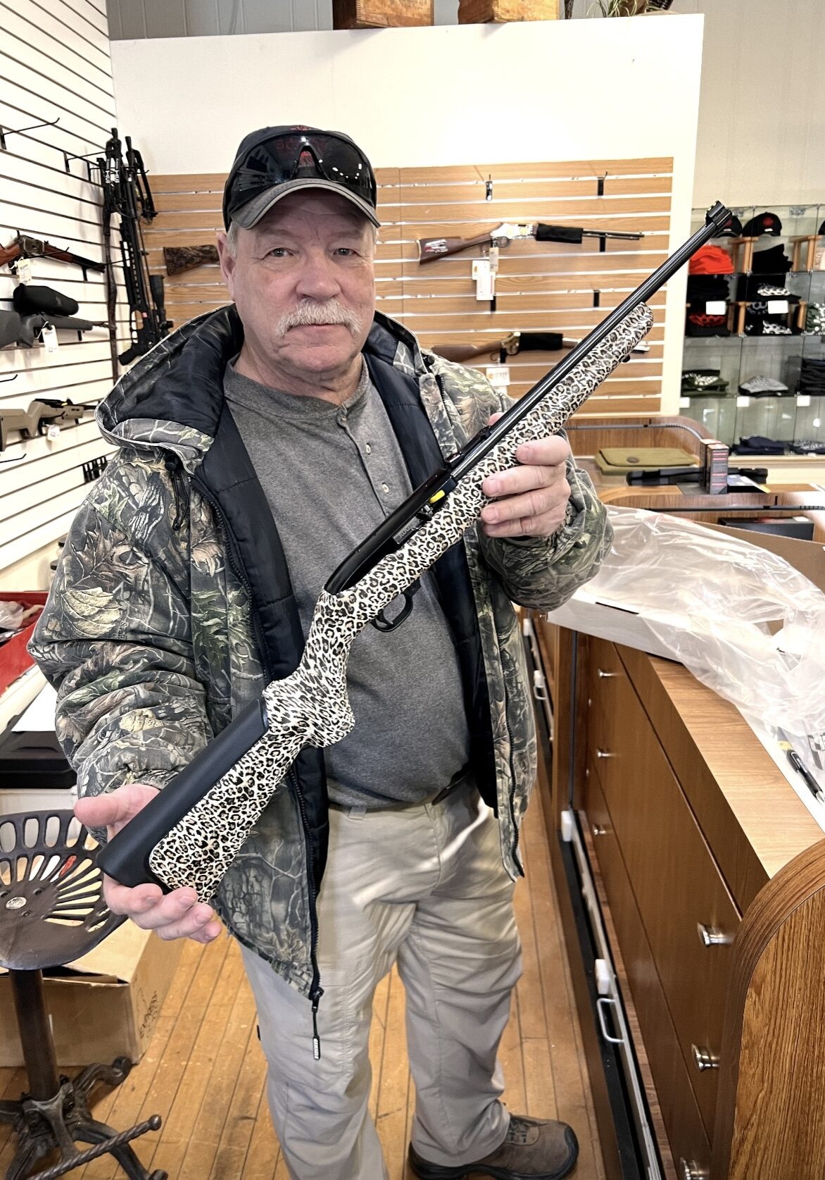Larry at the River Valley Arms and Ammo store holding a rifle